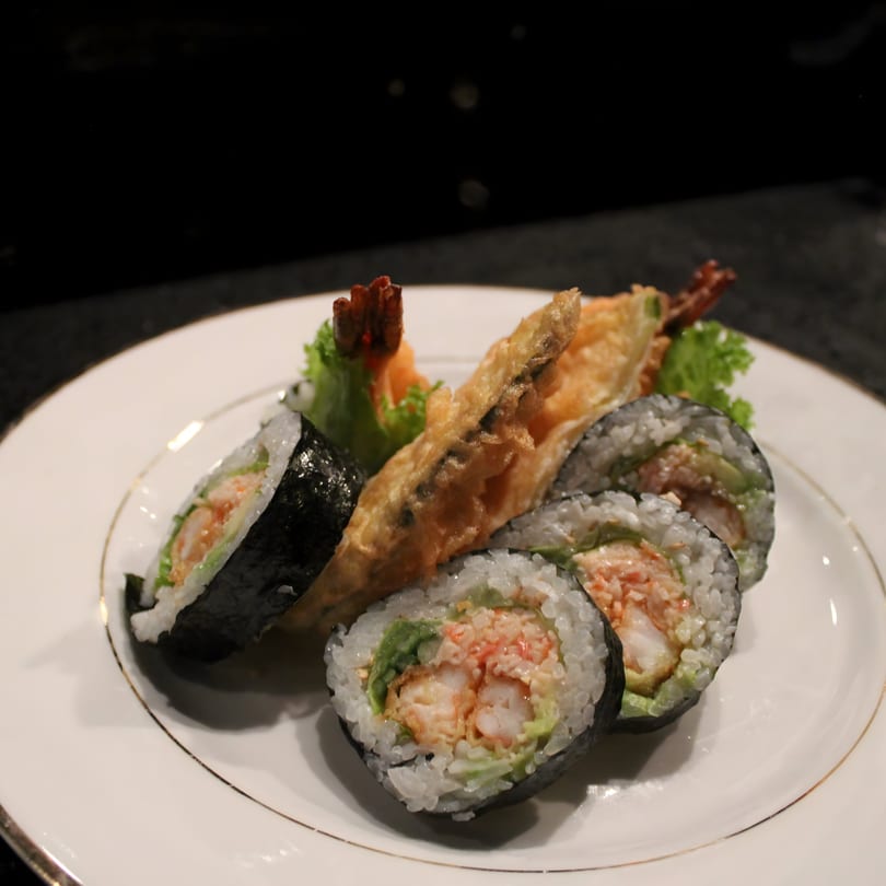 Uni Sushi's shrimp tempura rolls and a piece of fried shrimp on a white plate.