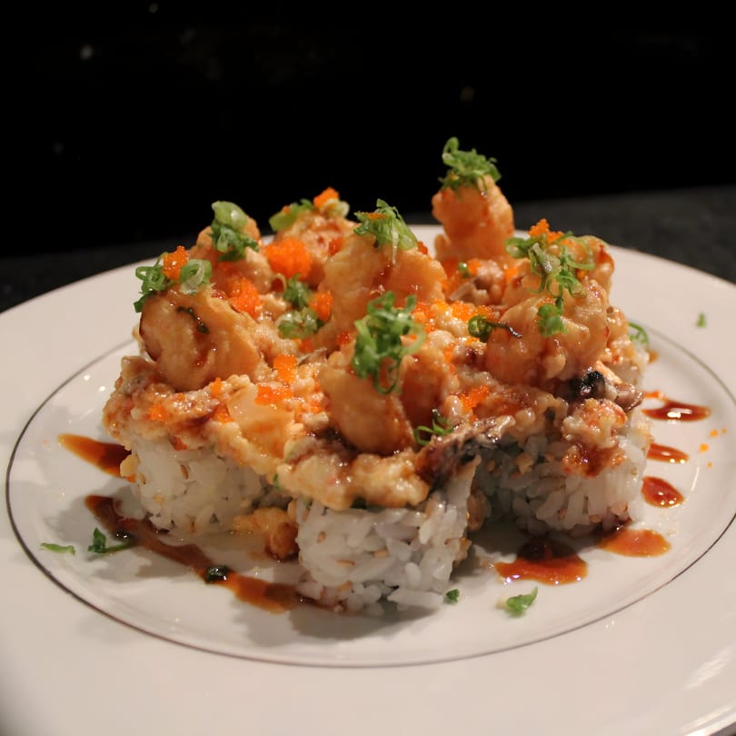 Uni Sushi's fried shrimp tempura sushi roll, topped with roe, green onions, and sauce.