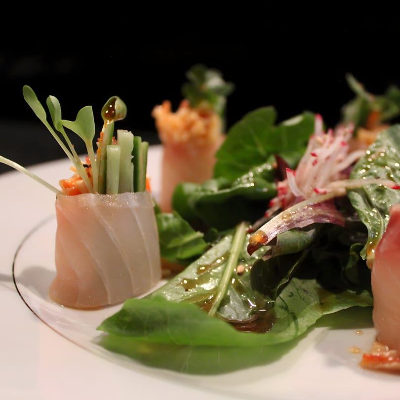 Uni Sushi's fresh sashimi rolls with cucumber, sprouts, and a side salad drizzled with dressing.