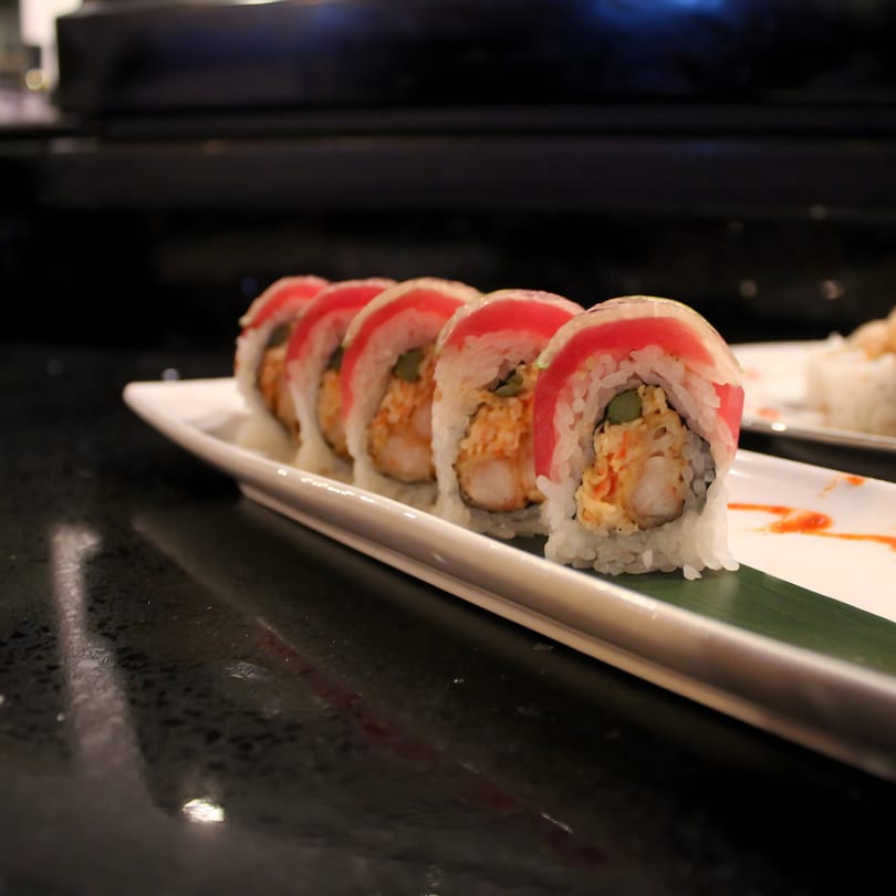 Uni Sushi's shrimp tempura rolls topped with tuna sashimi, served on a white rectangular plate.